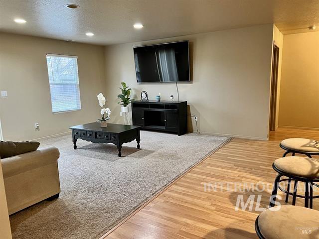 6498 South Lighthouse Place Boise, ID 83709 - Photo 5 of 16 Living area featuring light wood finished floors, recessed lighting, and a textured ceiling