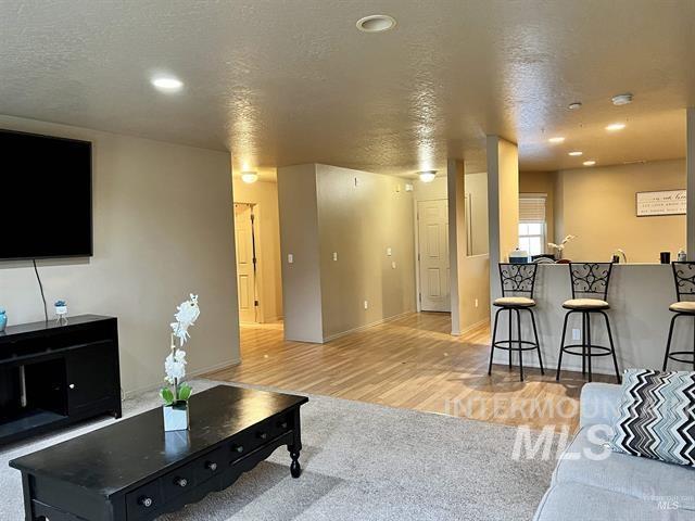 6498 South Lighthouse Place Boise, ID 83709 - Photo 6 of 16 Living room with a textured ceiling, recessed lighting, and light carpet