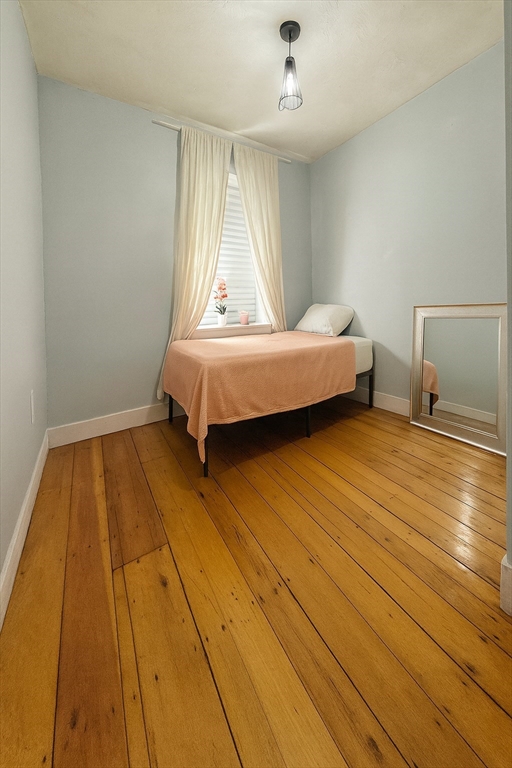 74 Davison Street Boston, MA 02136 - Photo 14 of 20 a bedroom with a bed and wooden floor