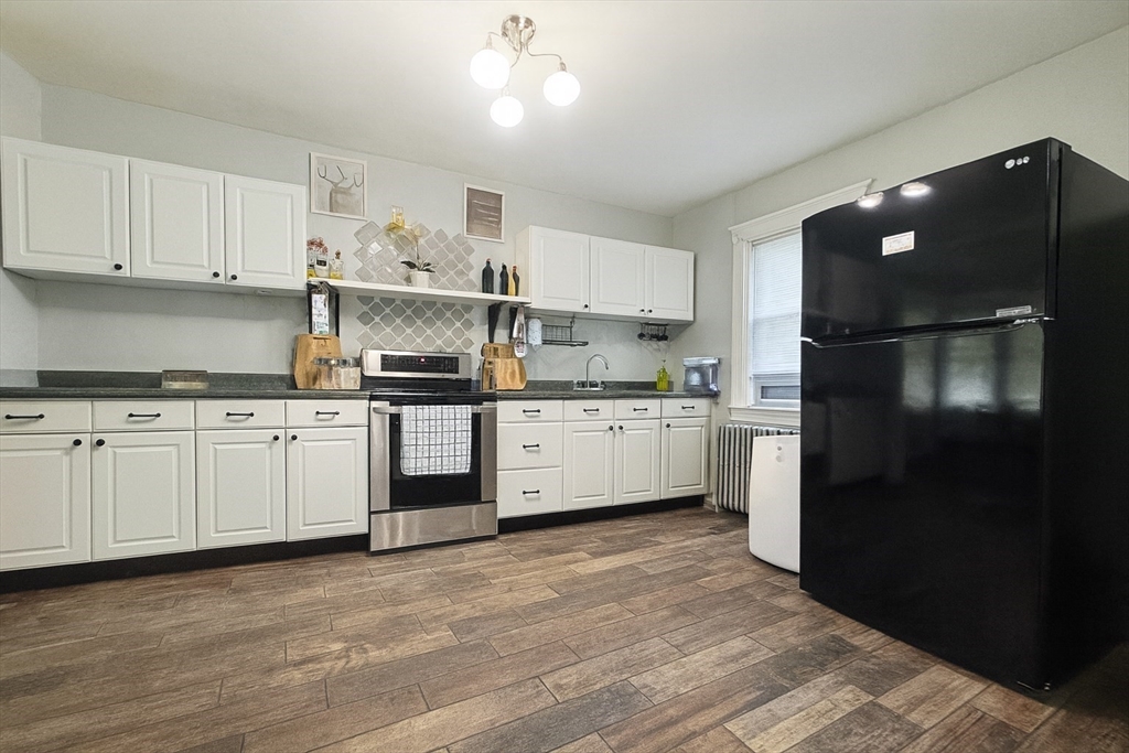74 Davison Street Boston, MA 02136 - Photo 5 of 20 a kitchen with white cabinets and refrigerator
