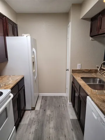 a utility room with wooden floor washer and dryer