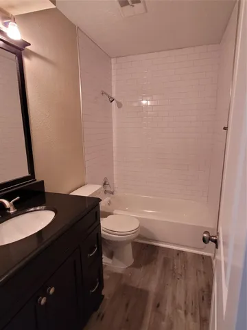 a bathroom with a granite countertop sink toilet a mirror and shower