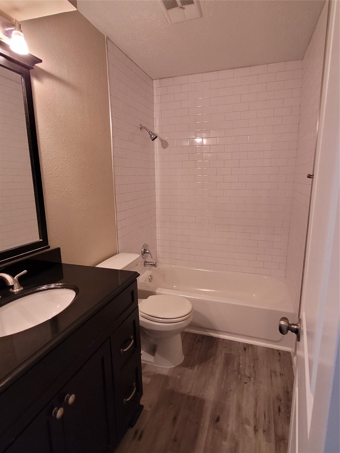 1516 Bay Area Boulevard, Unit S2 Houston, TX 77058 - Photo 8 of 11 a bathroom with a granite countertop sink toilet a mirror and shower