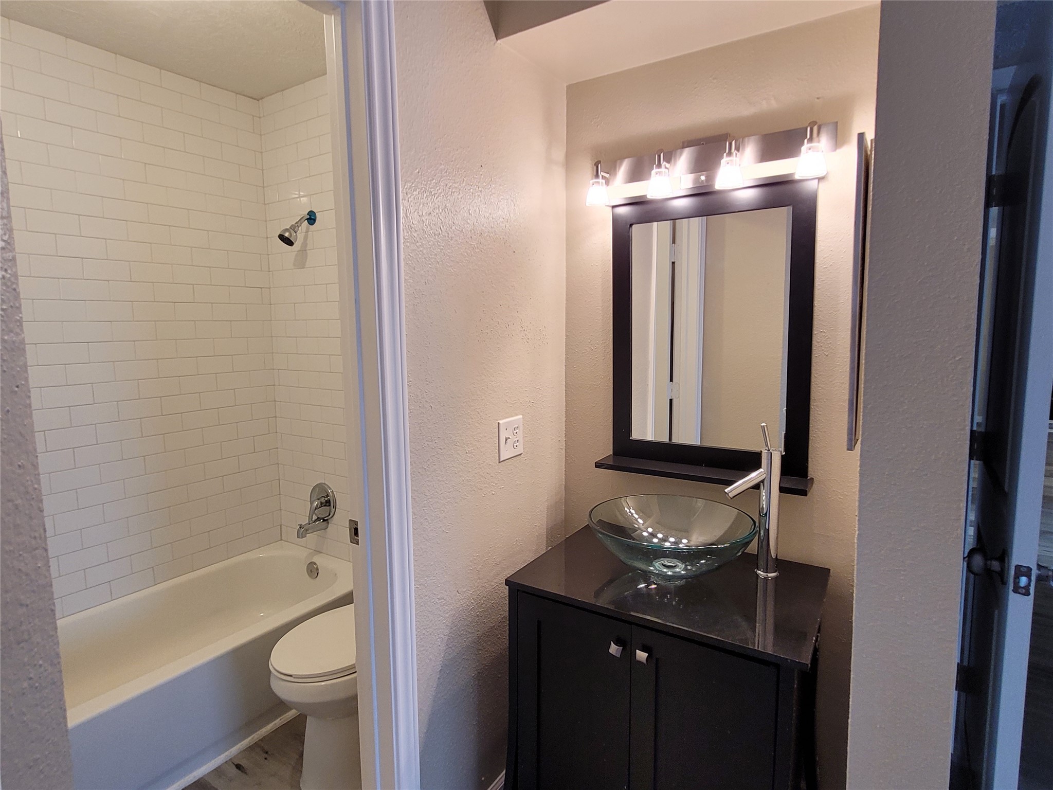 1516 Bay Area Boulevard, Unit S2 Houston, TX 77058 - Photo 10 of 11 a bathroom with a sink a toilet a mirror and bathtub