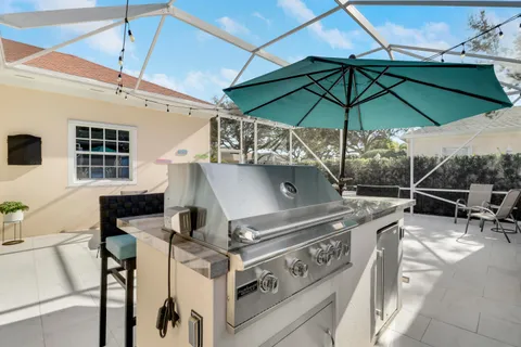 a roof deck with table and chairs under an umbrella