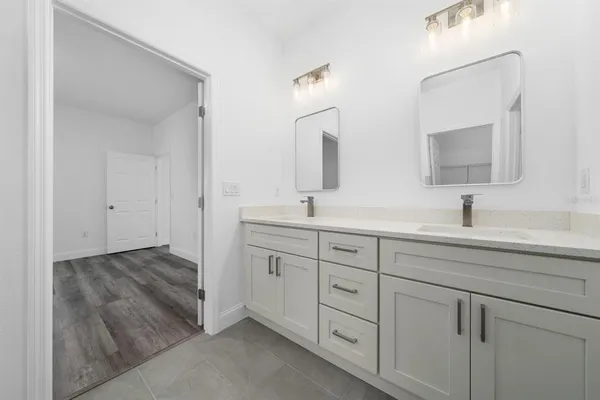 a spacious bathroom with a shower sink and mirror