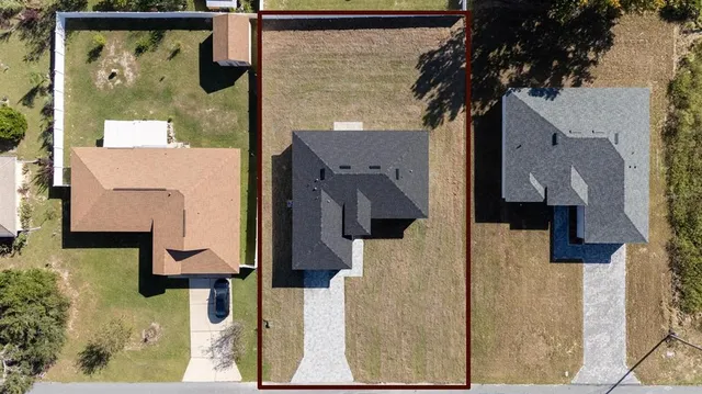 an aerial view of residential houses with outdoor space and swimming pool