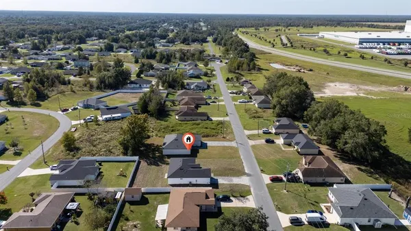 an aerial view of ocean and residential houses with outdoor space