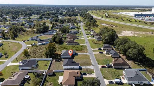 an aerial view of ocean and residential houses with outdoor space