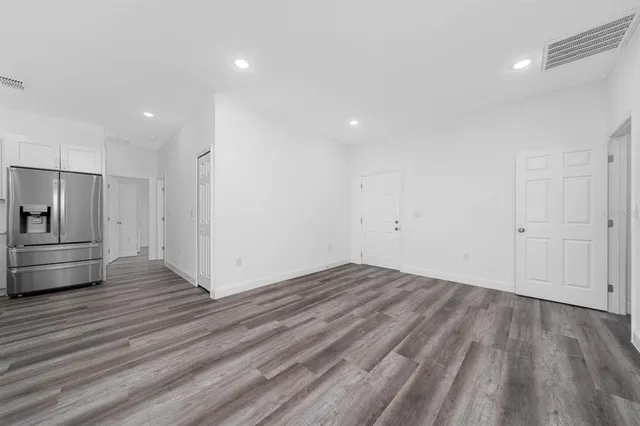a view of empty room with wooden floor