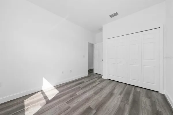 a view of an empty room with wooden floor