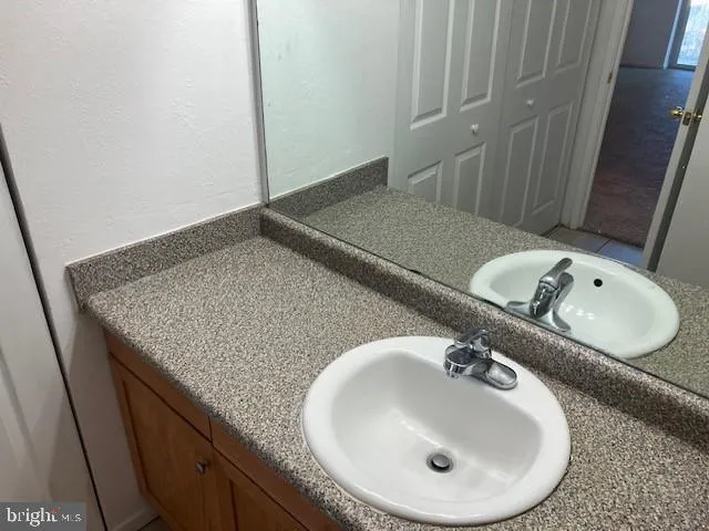 a bathroom with a granite countertop sink and a mirror