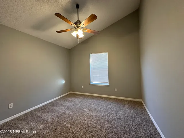 an empty room with a window and a fan