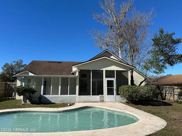 a view of house with yard outdoor seating and swimming pool