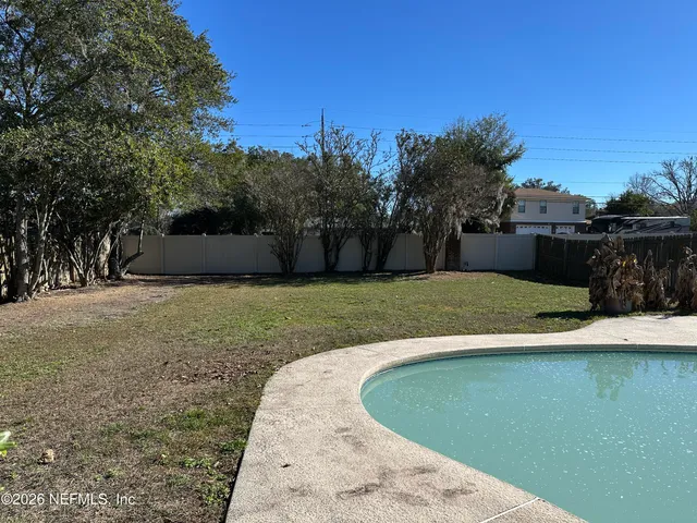 a view of a swimming pool with a yard