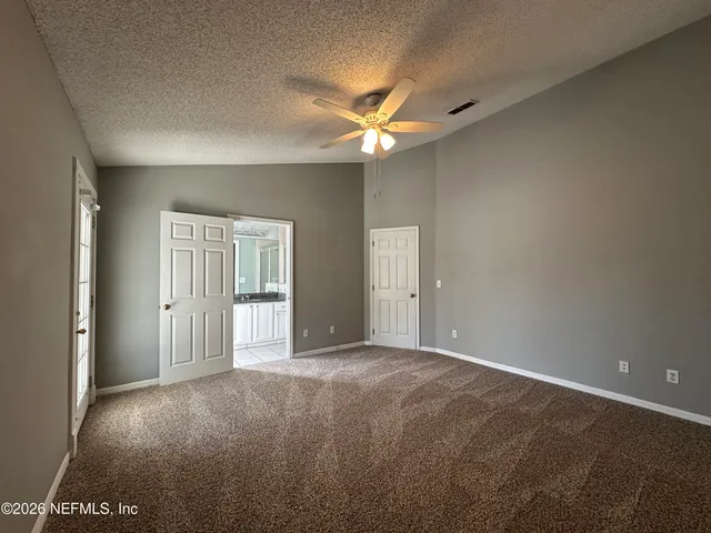 a view of an empty room with a ceiling fan