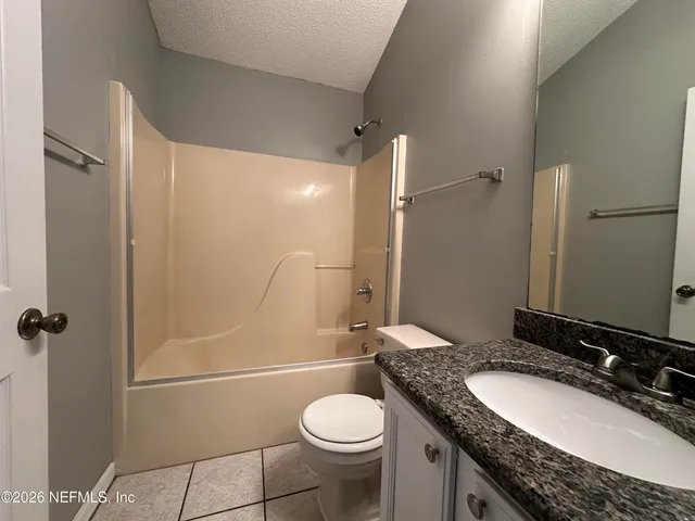 a bathroom with a granite countertop toilet sink and shower