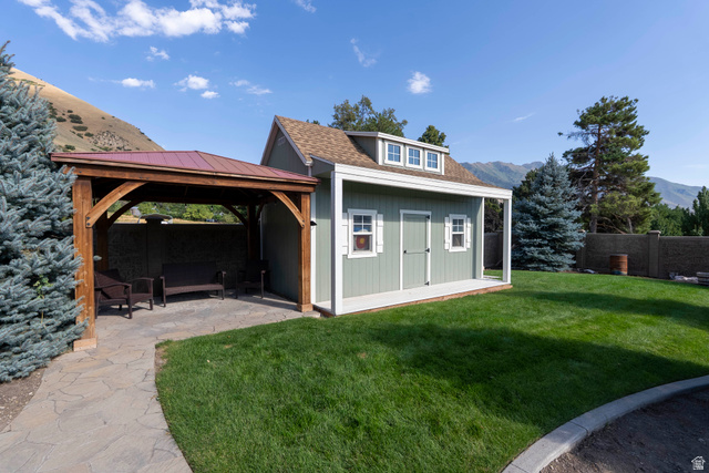 687 South 2080th Street East Springville, UT 84663 - Photo 108 of 149 Expansive lawn featuring a detached shed with a front porch, white shutters, and a dormer