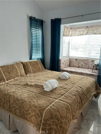 a bedroom with a bed and next to a window