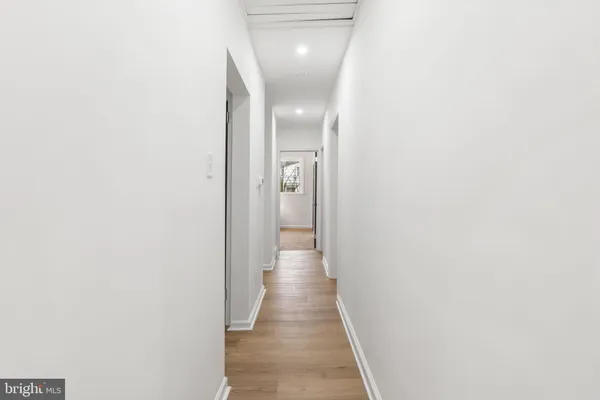 a view of a hallway with wooden floor
