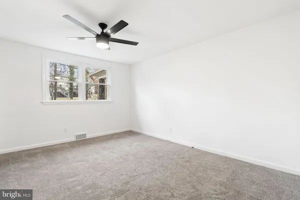 an empty room with a window and a ceiling fan