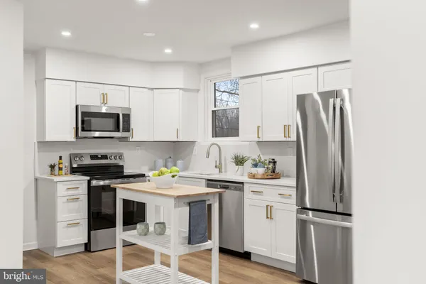 a kitchen with stainless steel appliances a refrigerator stove and microwave