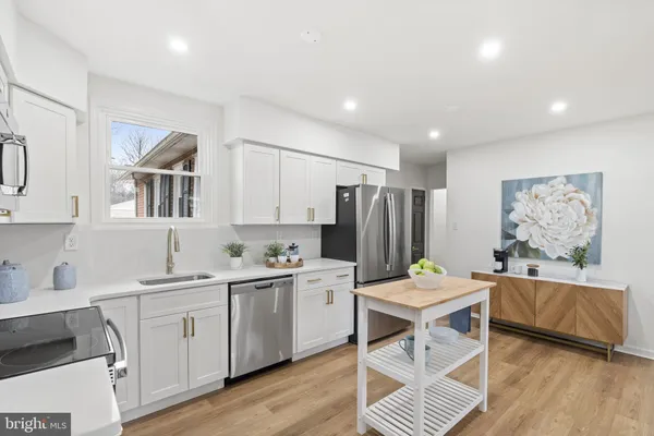 a kitchen with a sink cabinets and wooden floor