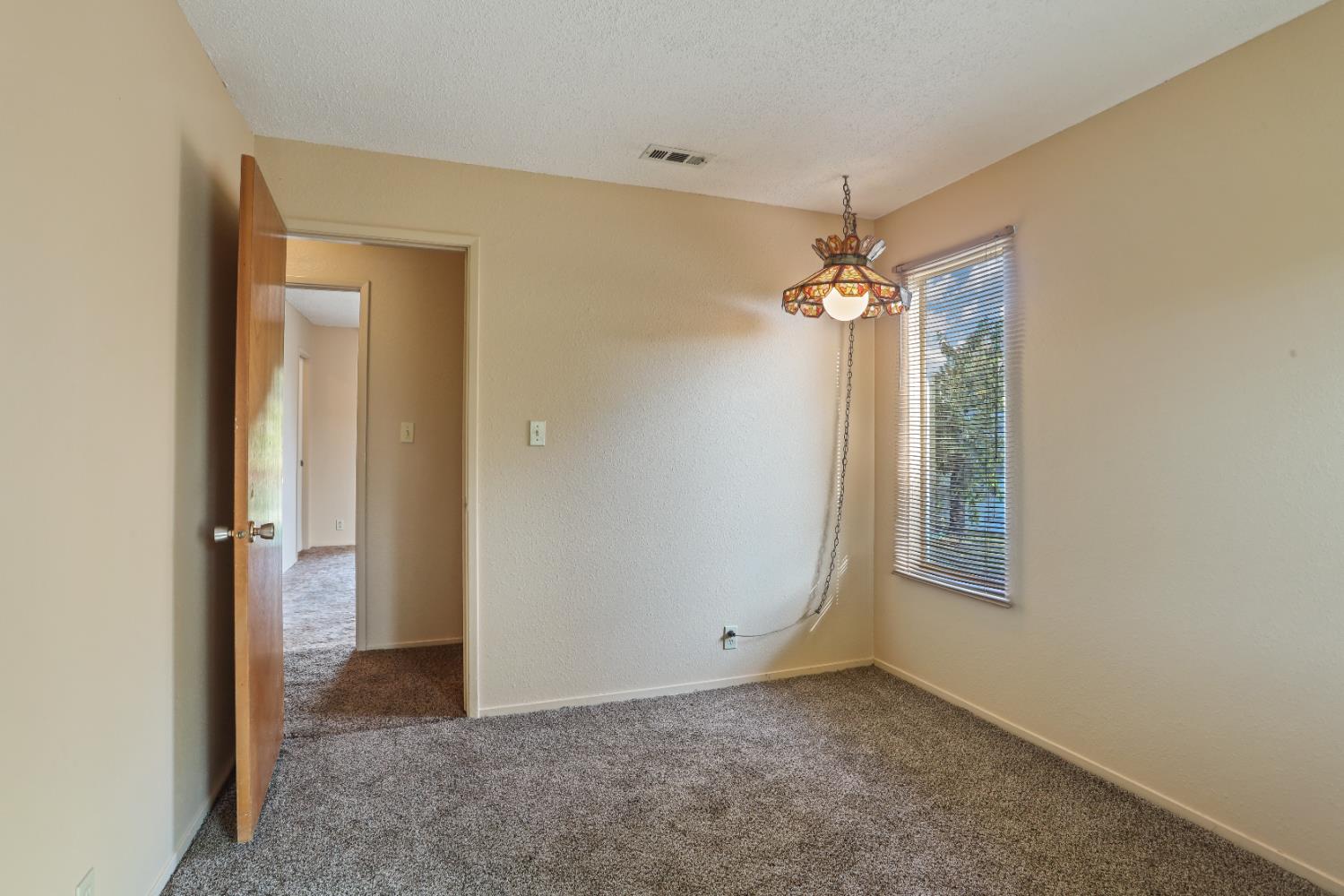 25523 East Groves Road Farmington, CA 95230 - Photo 24 of 65 a view of a hallway with a chandelier fan and windows