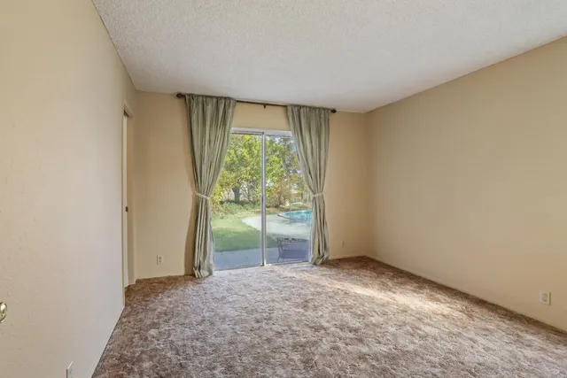 a view of empty room with floor to ceiling window and fireplace