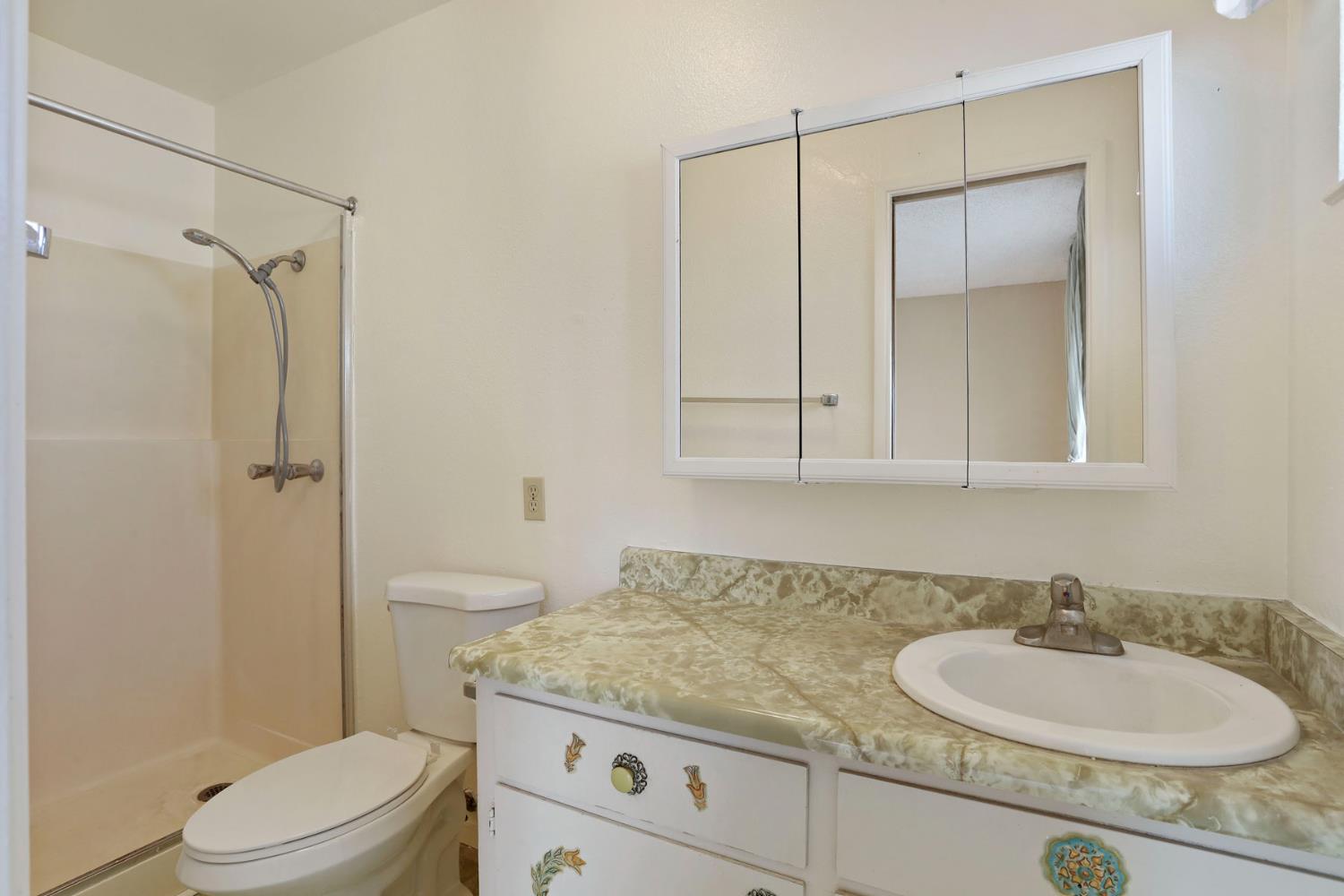 25523 East Groves Road Farmington, CA 95230 - Photo 27 of 65 a bathroom with a granite countertop sink a toilet and shower