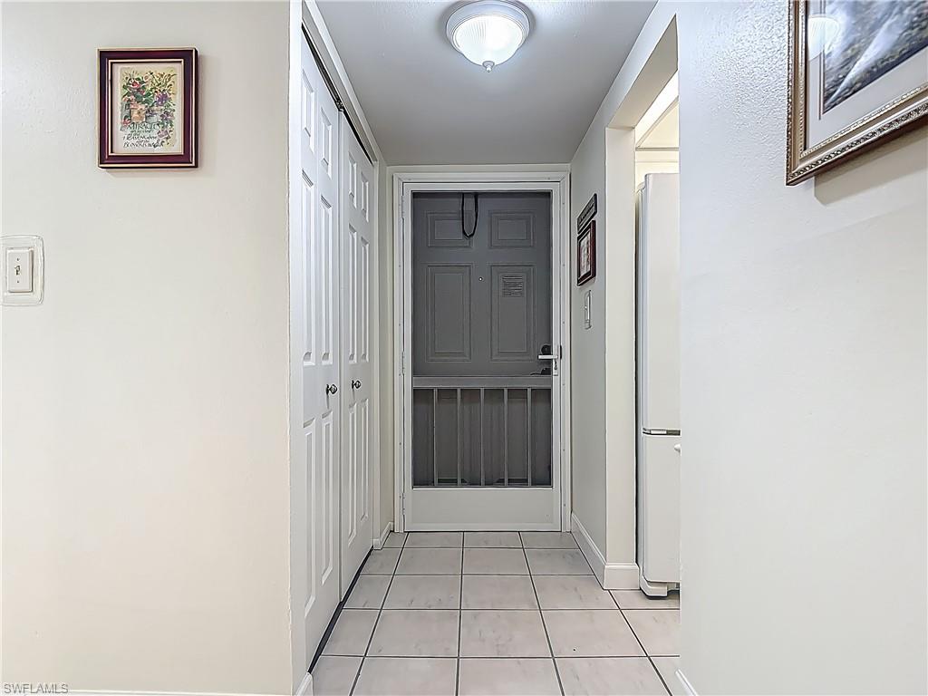 175 Turtle Lake Court, Unit 108 Naples, FL 34105 - Photo 2 of 17 Hall featuring light tile patterned flooring and baseboards