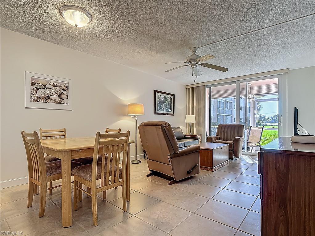 175 Turtle Lake Court, Unit 108 Naples, FL 34105 - Photo 7 of 17 Dining space with ceiling fan, light tile patterned floors, baseboards, and a textured ceiling