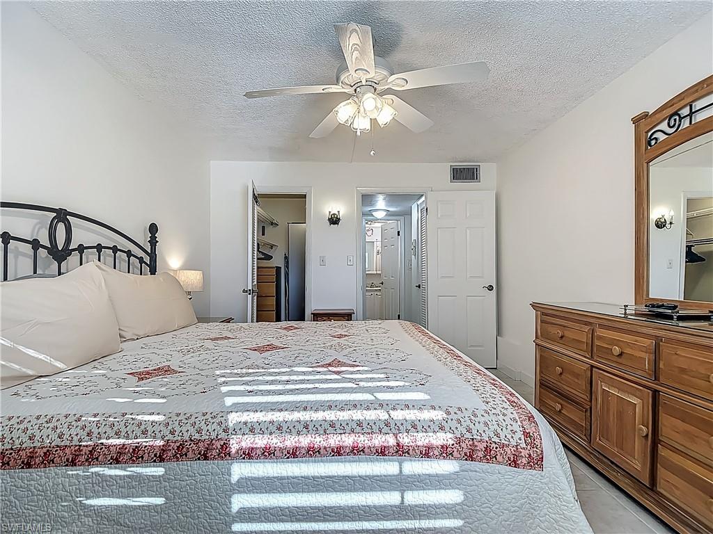 175 Turtle Lake Court, Unit 108 Naples, FL 34105 - Photo 9 of 17 Bedroom with a textured ceiling, a ceiling fan, and light tile patterned floors