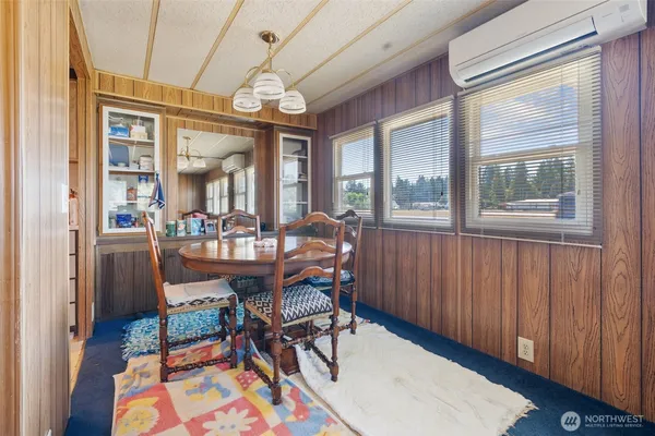 a dining room with furniture a chandelier and wooden floor
