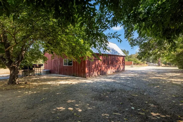 a view of a house with a dry yard with wooden fence