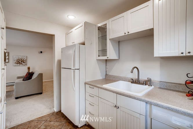 13801 Old Redmond Road, Unit A101 Redmond, WA 98052 - Photo 7 of 25 a kitchen with a sink a refrigerator and cabinets