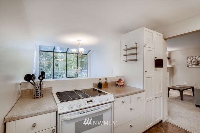 13801 Old Redmond Road, Unit A101 Redmond, WA 98052 - Photo 8 of 25 a kitchen with stainless steel appliances white cabinets and a stove top oven