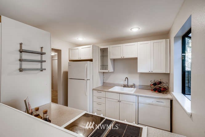 13801 Old Redmond Road, Unit A101 Redmond, WA 98052 - Photo 9 of 25 a kitchen with a refrigerator and white cabinets