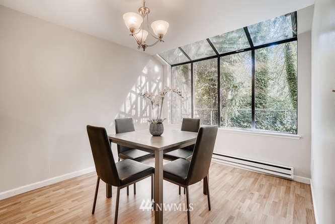 13801 Old Redmond Road, Unit A101 Redmond, WA 98052 - Photo 10 of 25 a view of a dining room with furniture a chandelier and wooden floor