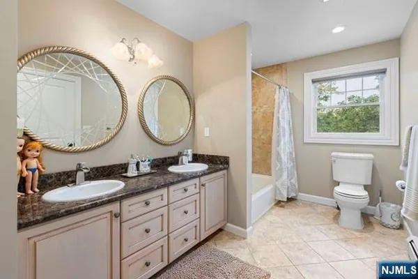 a bathroom with a granite countertop double vanity sink and a mirror