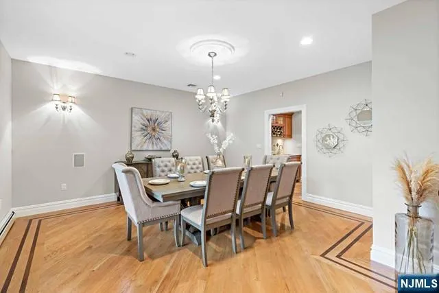 a dining room with furniture a chandelier and wooden floor