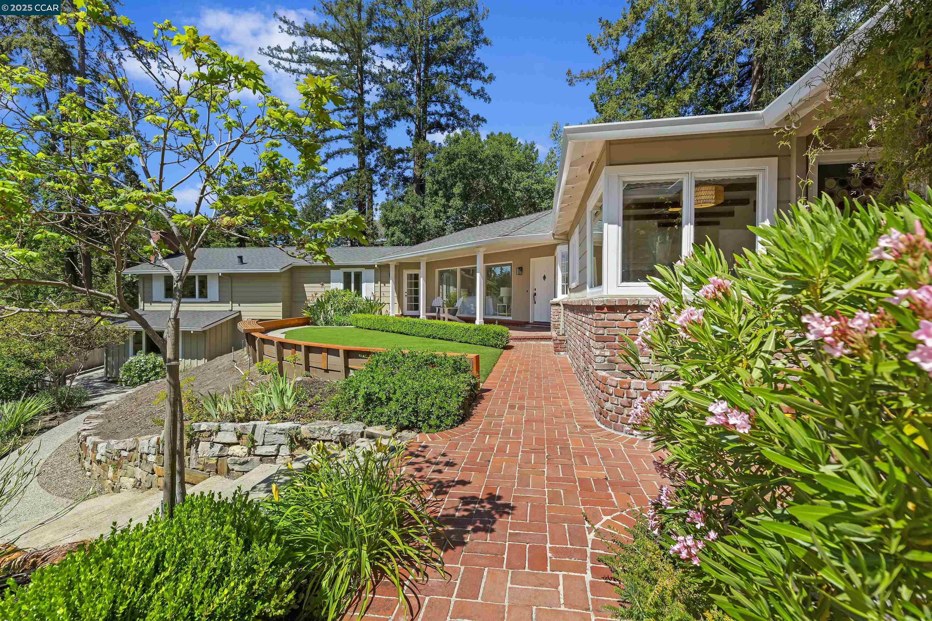 a view of a house with brick walls and a yard with plants
