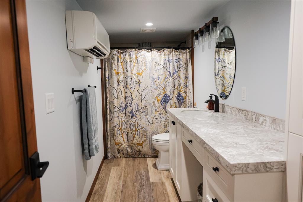 1250 County Road Brady, TX 76825 - Photo 23 of 40 a bathroom with a granite countertop sink toilet and shower