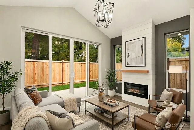 a living room with furniture large windows and a fireplace