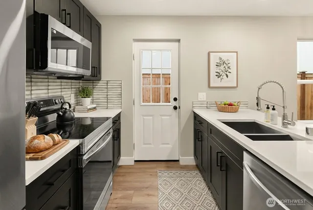 a kitchen with stainless steel appliances granite countertop a sink stove and cabinets