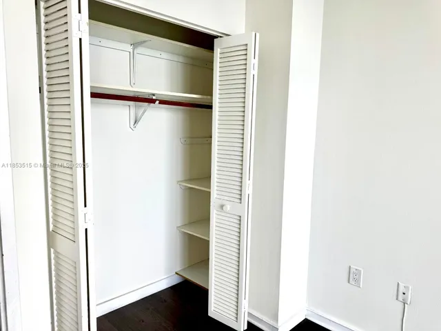 a view of walk in closet with empty racks