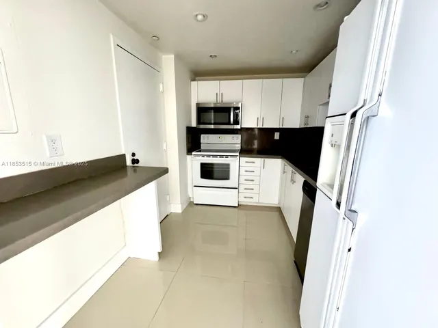 a kitchen with stainless steel appliances a refrigerator sink and microwave