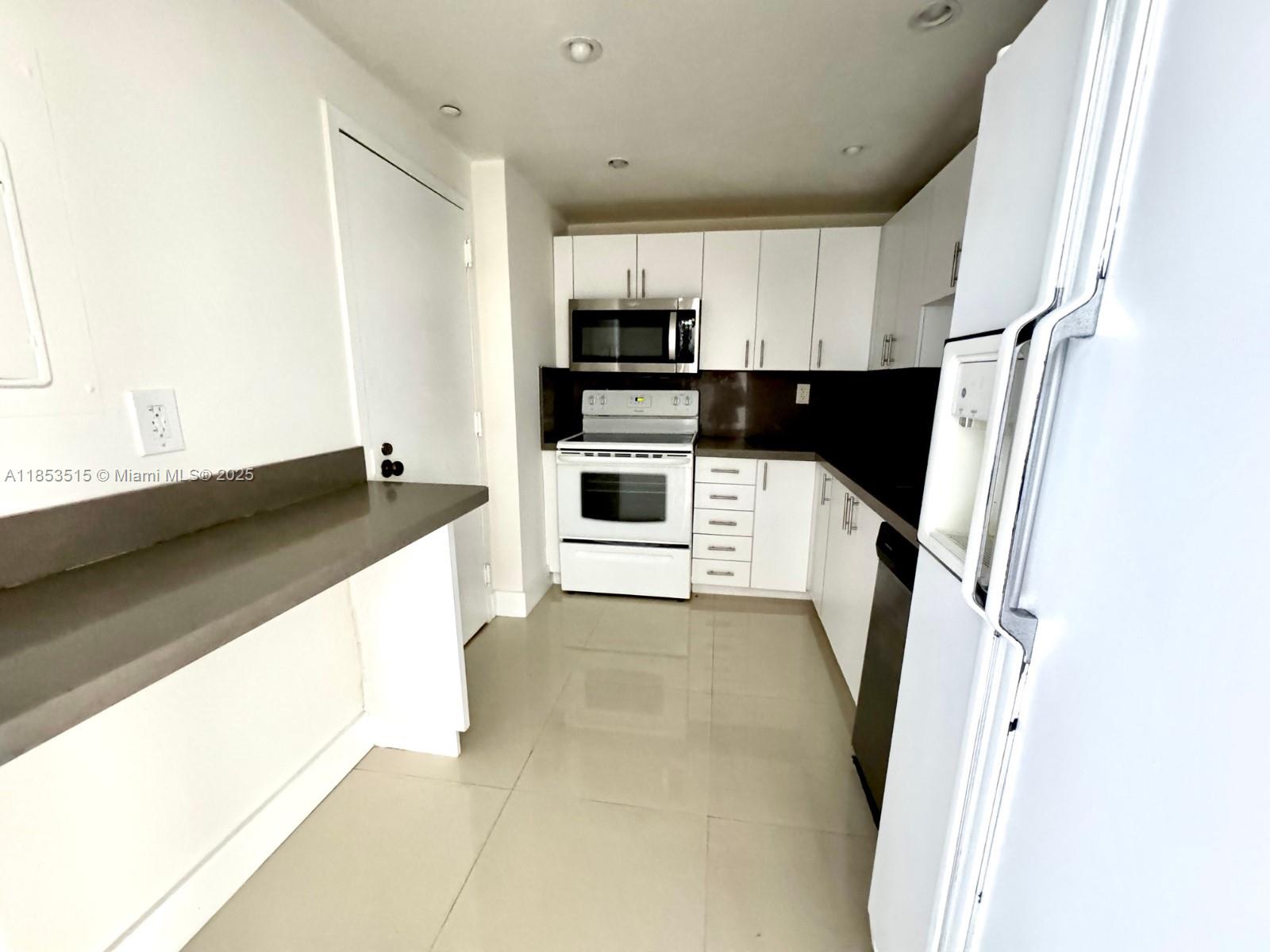 2333 Brickell Avenue, Unit 2607 Miami, FL 33129 - Photo 4 of 23 a kitchen with stainless steel appliances a refrigerator sink and microwave