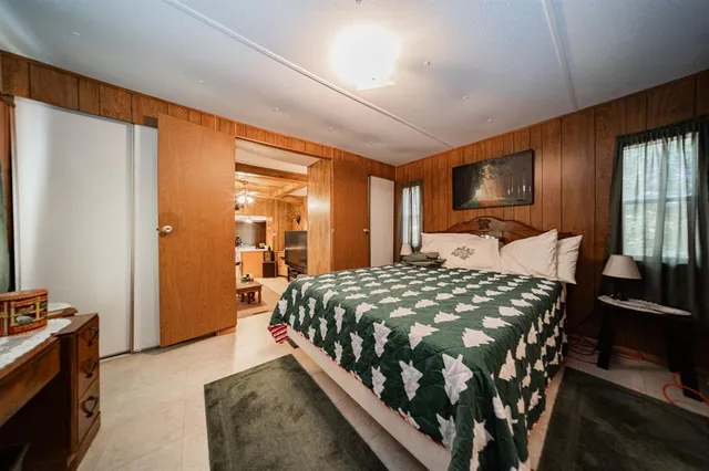 a bedroom with a large bed and a flat tv screen on dresser