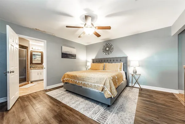 a spacious bedroom with a large bed and a chandelier